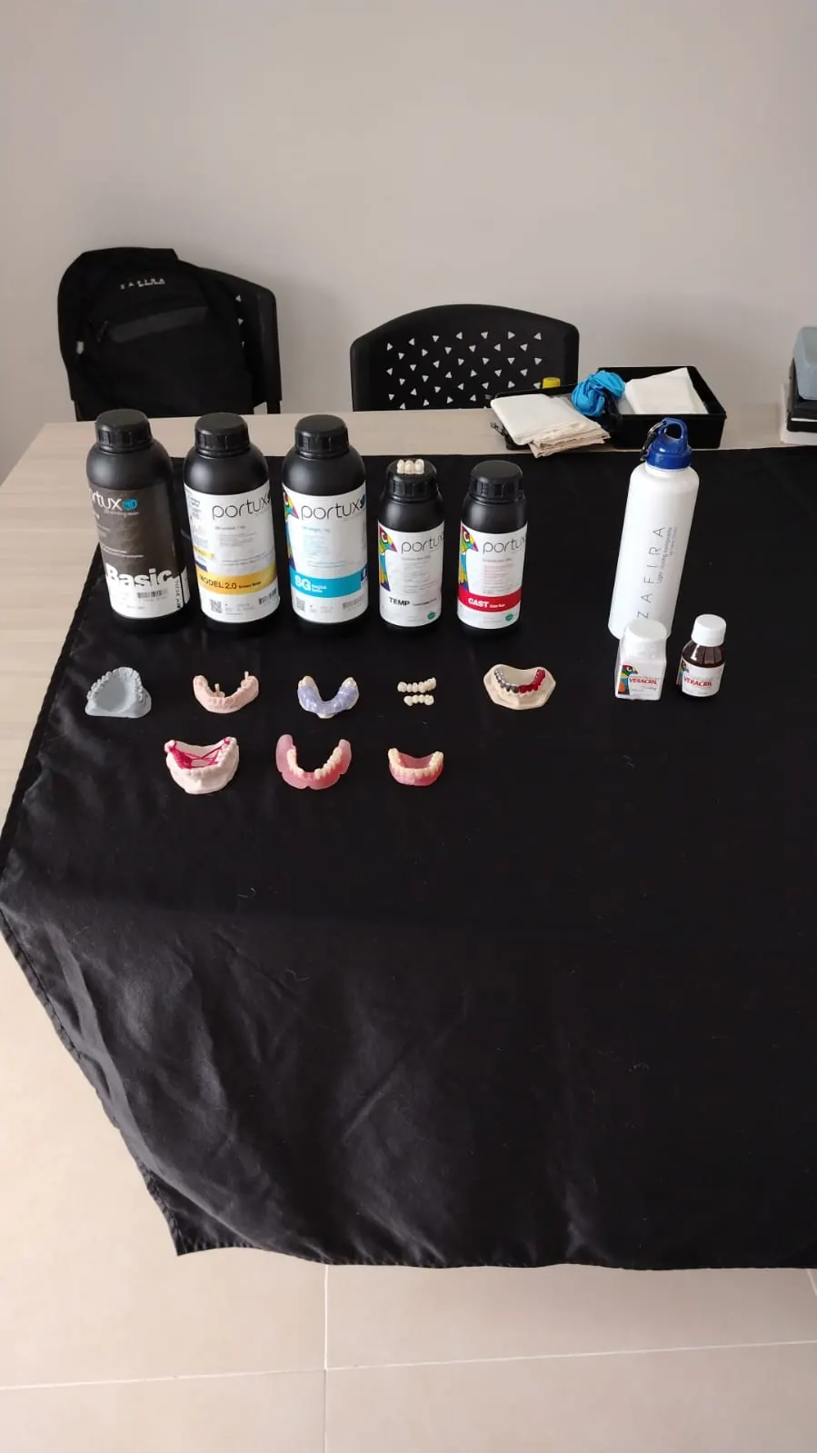 Mesa con frascos de resina Portux 3D y modelos dentales impresos